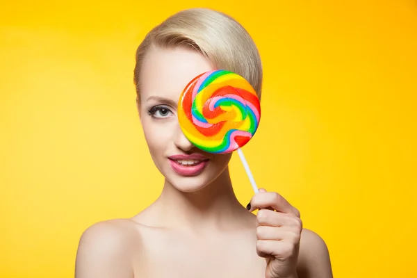 Vrolijke blondie met lollipop die betrekking hebben op ogen — Stockfoto