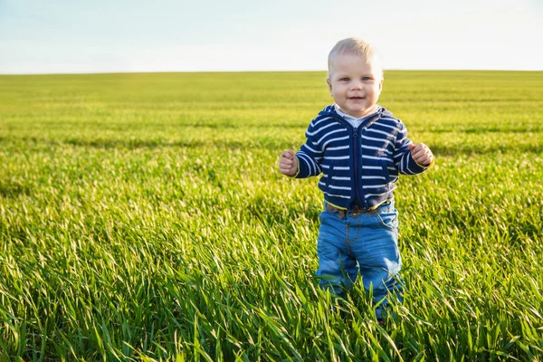 Hermoso niño de pie en la hierba verde — Foto de Stock