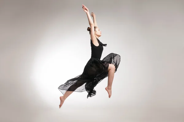 Nuori baletti tanssija yllään musta läpinäkyvä mekko hyppääminen — kuvapankkivalokuva