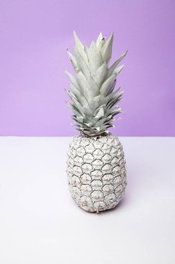 Beyaz ananas stüdyoda, menekşe arka planda.