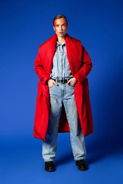 Confident female model in baggy clothes against blue background — Stock Photo, Image