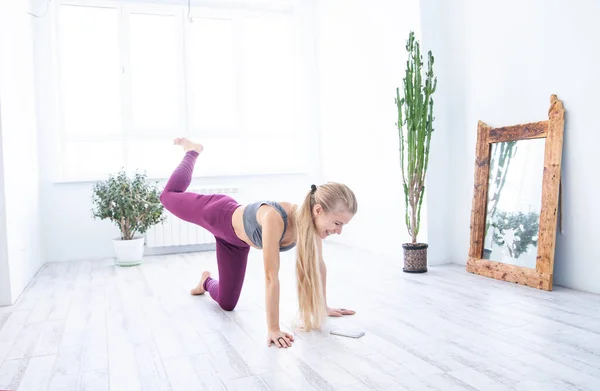 Slim sportswoman exercising in cozy room at home — Stock Photo, Image