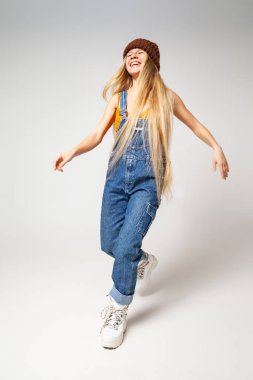 Modayı takip eden enerjik hippi kadın stüdyoda dans ediyor.