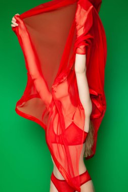 Peçeli, kırmızı iç çamaşırlı zayıf bir kadın.