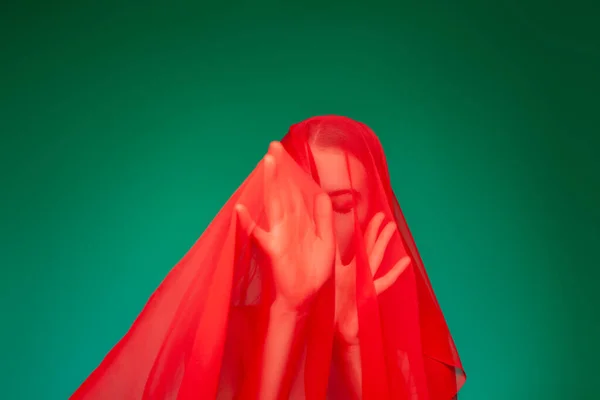 Donna sognante sotto il velo rosso sullo sfondo verde — Foto Stock