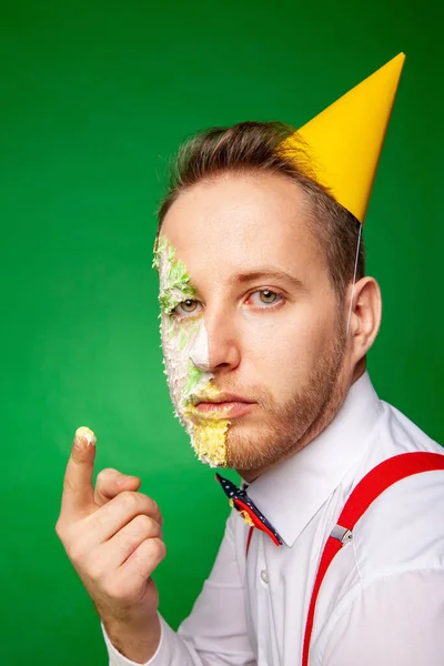 Hombre degustación de pastel de cumpleaños sobre fondo verde —  Fotos de Stock