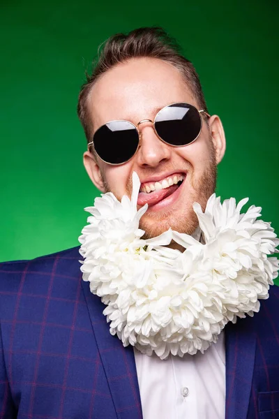 Vrolijke man met bloemen op de hals en in pak in de studio — Stockfoto
