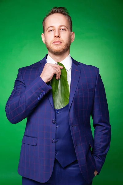 Stijlvolle man in pak en stropdas van groen blad — Stockfoto