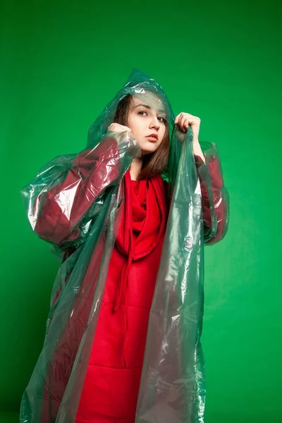 Mulher de capa de chuva de pé em estúdio sobre fundo verde — Fotografia de Stock