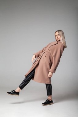 Zarif ceketli genç bayan saçlarına dokunuyor.