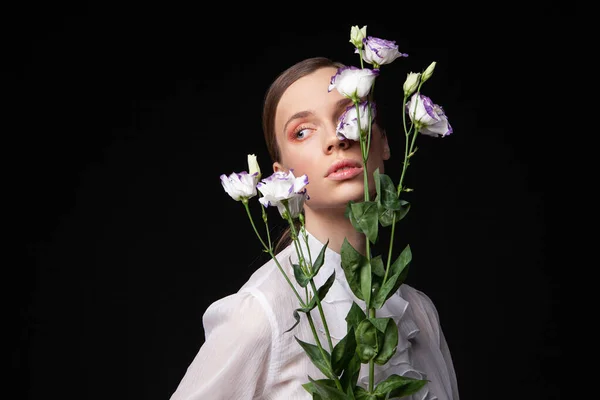 Elegante jonge vrouwelijke model met delicate bloemen — Stockfoto