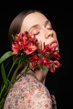 Genç bayan taze çiçeklerin yumuşaklığından zevk alıyor.