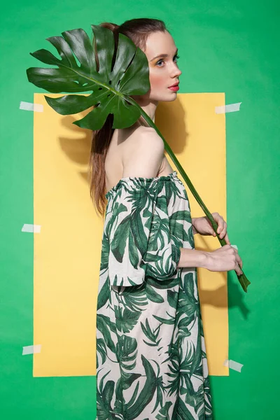 Mujer joven en vestido de verano sosteniendo la hoja —  Fotos de Stock