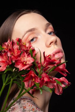 Genç bayan taze çiçeklerin yumuşaklığından zevk alıyor.