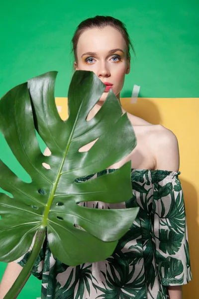Jonge vrouw in de zomer jurk vasthouden blad — Stockfoto