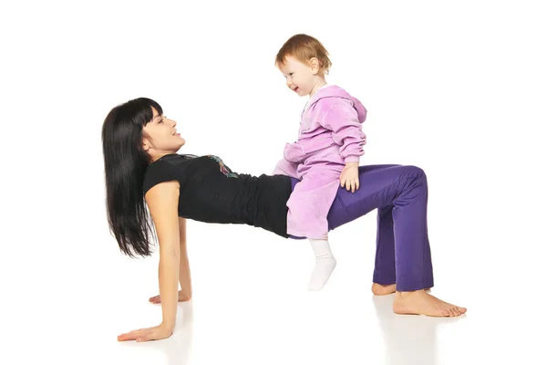 Мама с ребенком делает упражнения над белым Стоковое Фото