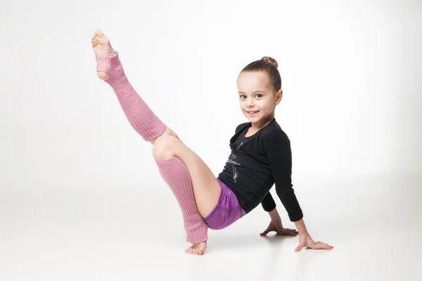 Bonita niña haciendo gimnasia sobre fondo blanco Imagen de archivo