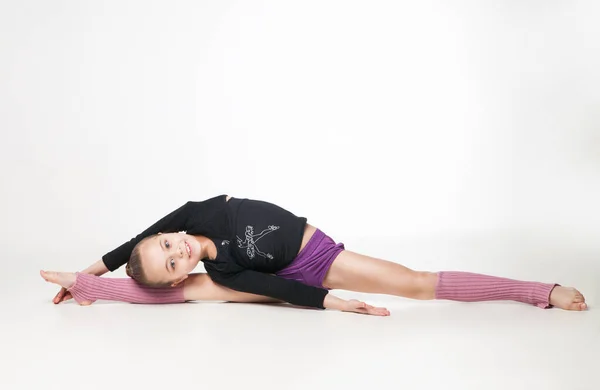 Jolie petite fille faire de la gymnastique sur fond blanc Photos De Stock Libres De Droits