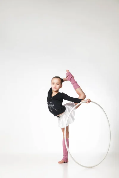 Bonita niña haciendo gimnasia sobre fondo blanco Imagen de archivo