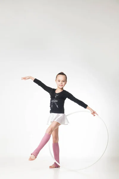 Красивая маленькая девочка занимается гимнастикой на белом фоне Лицензионные Стоковые Фото