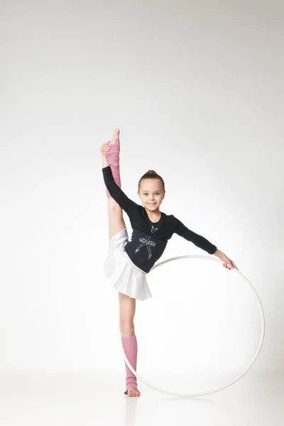 Красивая маленькая девочка занимается гимнастикой на белом фоне Лицензионные Стоковые Изображения