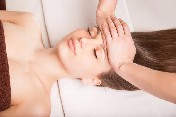 Jovem mulher brilhante recebendo massagem na cabeça — Fotografia de Stock