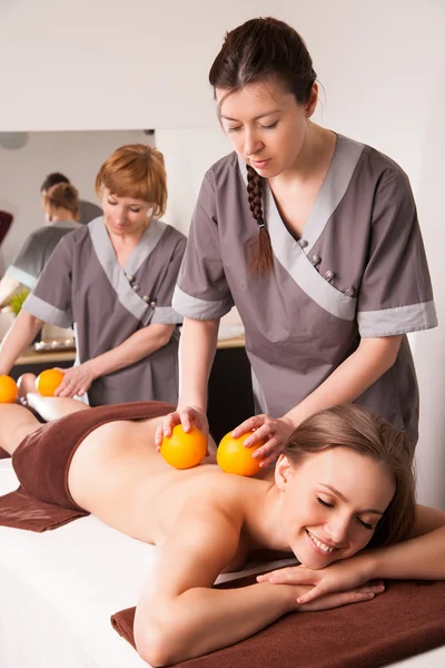 Frau erhält Behandlungen mit Orangen im Spa — Stockfoto