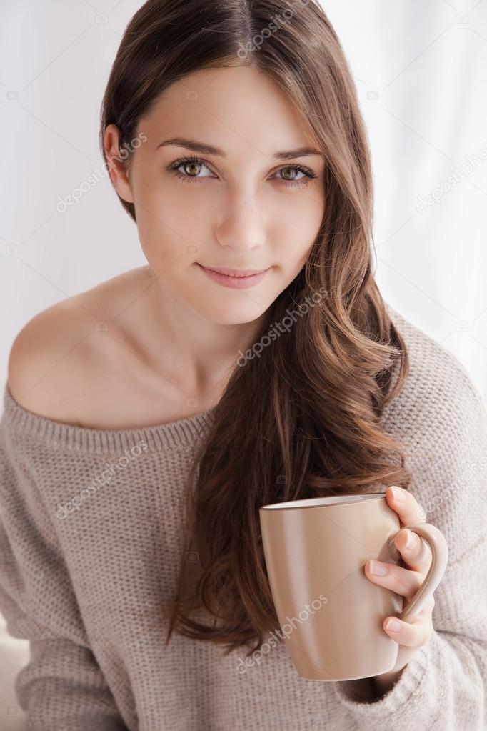 beautiful woman drinking coffee, sitting by window