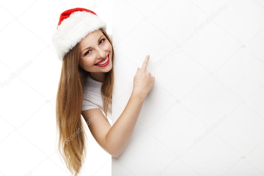 Christmas woman in santa hat pointing empty board