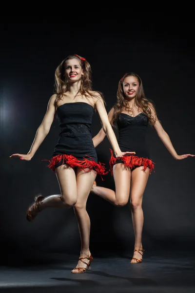 Two cabaret dancers in bright costumes over dark — Stock Photo, Image