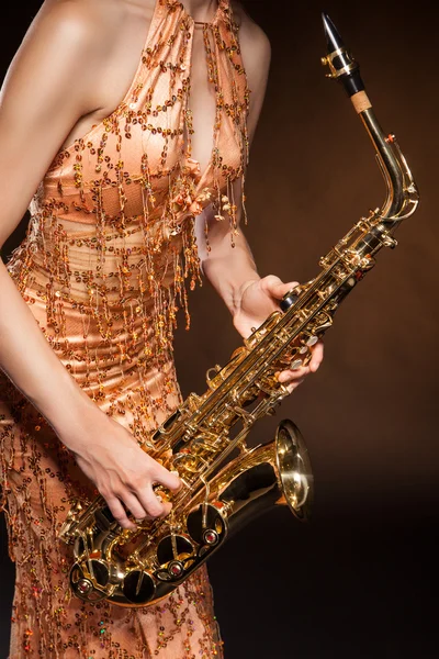 Sexuální mladá žena pózuje s saxofon ve studiu — Stock fotografie