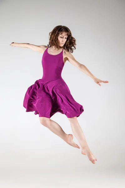 Jovem bailarina de balé vestindo vestido roxo sobre cinza — Fotografia de Stock