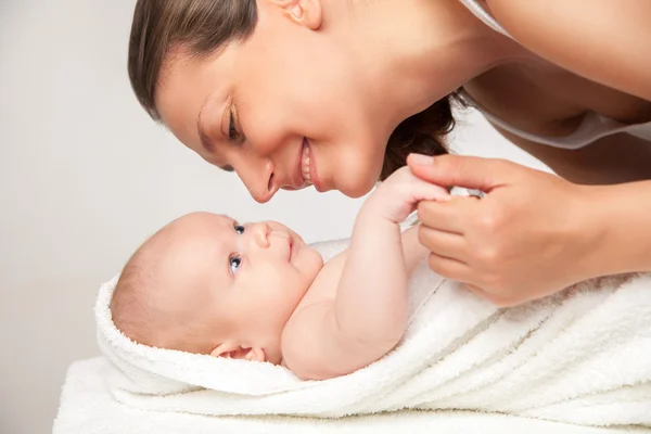 Mãe feliz com seu bebê envolto em toalha — Fotografia de Stock