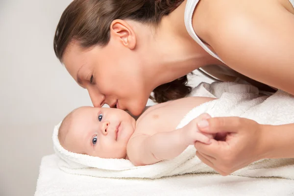 Happy mother with her baby wrapped into towel — Stock Photo, Image