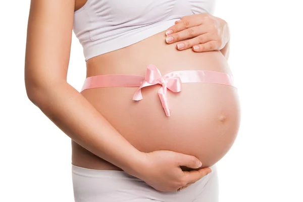 Beyaz üzerine pembe kurdele ile hamile kadın mide — Stok fotoğraf