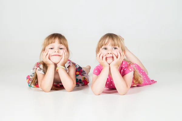 Dos niñas tendidas en el suelo y mirando hacia arriba — Foto de Stock