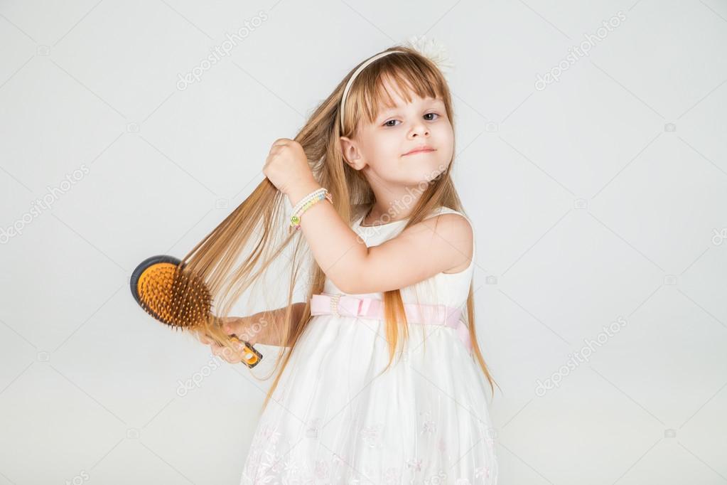 Smiling little girl brushing her hair closeup — Stock Photo