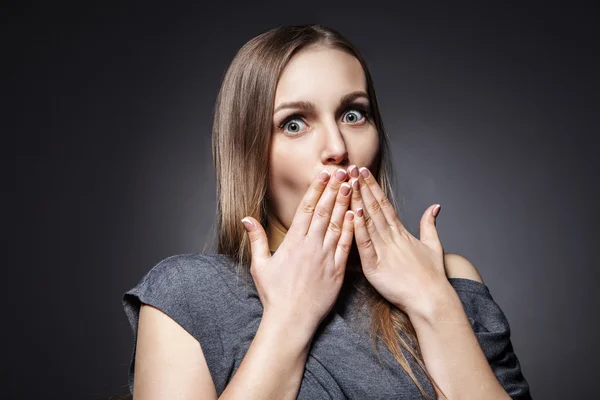 Suprised young woman on dark grey — Stock Photo, Image