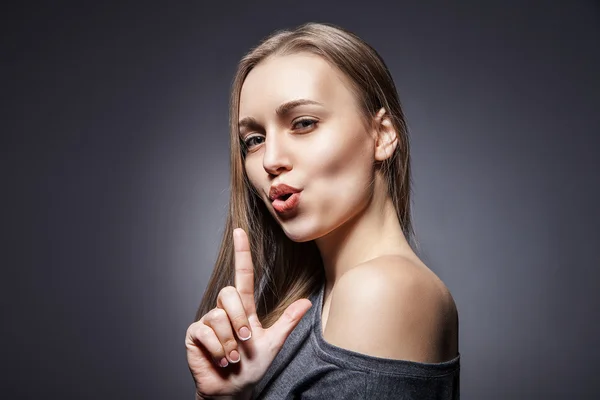 Vrouw te doen alsof om te schieten met haar vinger — Stockfoto