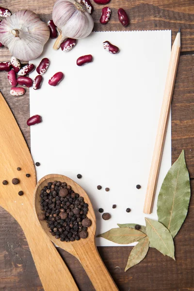 Paper for recipes and spices on wooden table — Stock Photo, Image