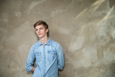 Yakışıklı adam rahat kıyafet ayakta gri karşı