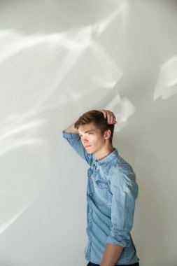 Yakışıklı adam rahat kıyafet ayakta gri karşı