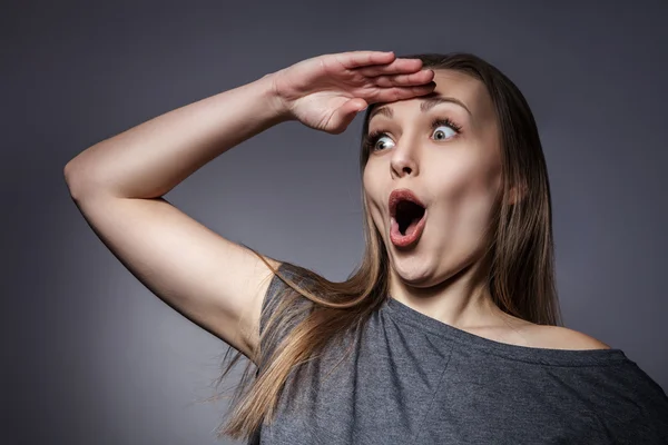 Mujer joven sorprendida en gris oscuro — Foto de Stock