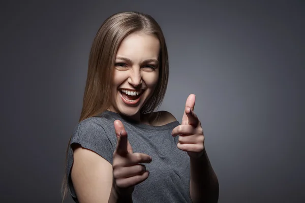Усміхнена жінка з нормальним жестом на темно-сірому — стокове фото