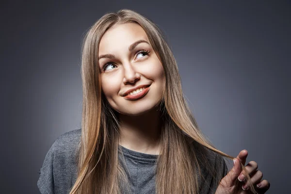 Attractive woman looking up over dark grey — Stock Photo, Image