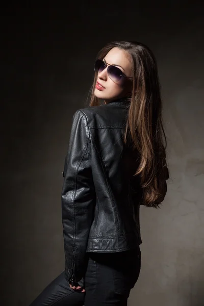 Aantrekkelijke vrouw in zwart lederen jas en broek — Stockfoto