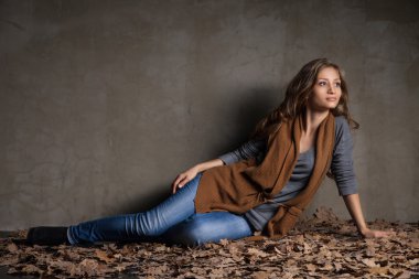 Genç kadın kot pantolon ile sonbahar yaprakları