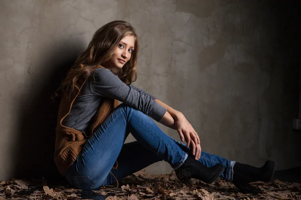 Young woman in jeans with autumn leaves — Stock Photo, Image