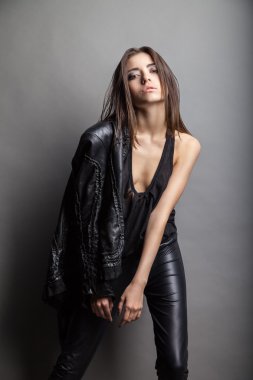 deri pantolon ve ceket giyen bir modeldir