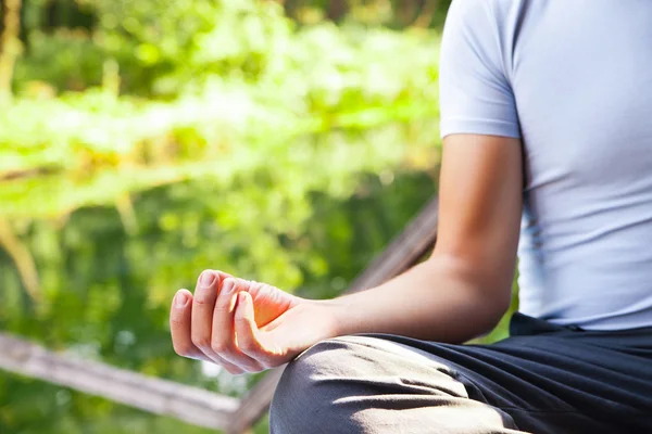 Junger Mann posiert im Park mit Yoga-Lotus — Stockfoto